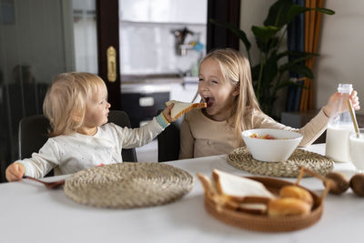 Portrait of boy eating food at home