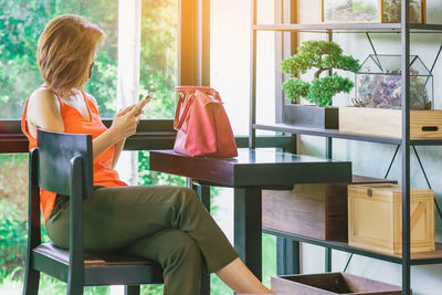 Rear view of woman sitting on chair at home