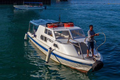 Man on boat moored in sea