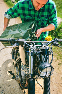 Man riding motorcycle on dirt road against sky