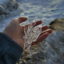 Close-up of hand holding sand at beach