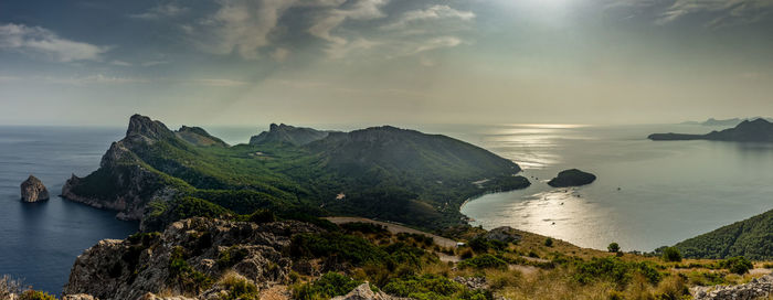 Scenic view of sea and mountains against sky