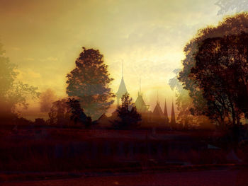 Trees in a temple against sky during sunset