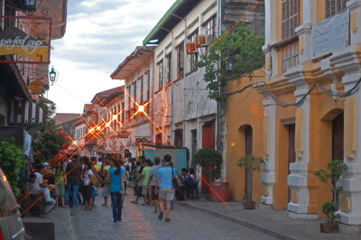 People walking on street amidst buildings in city