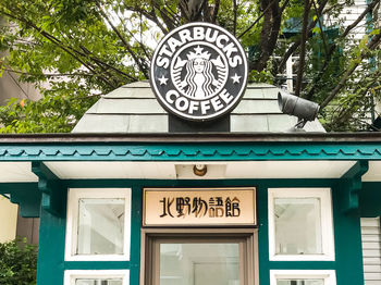 Low angle view of sign against trees