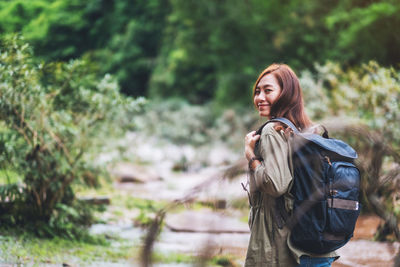 A female traveler with backpack walking by mountain stream for hiking concept