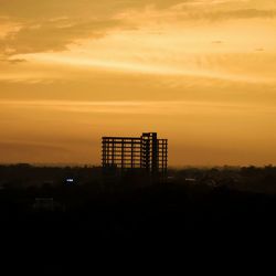 Silhouette built structure against sky during sunset