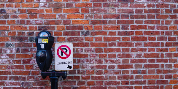 Close-up of sign on brick wall