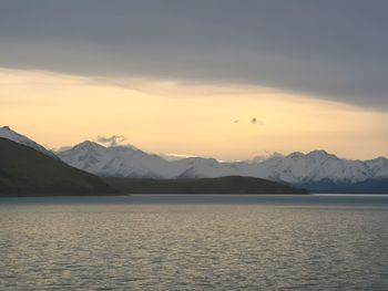 Scenic view of lake and mountains against sky during sunset