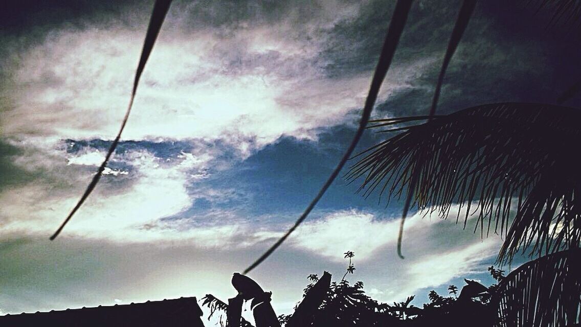 low angle view, sky, cloud - sky, silhouette, cloudy, lifestyles, leisure activity, men, cloud, technology, outdoors, unrecognizable person, standing, part of, street light, dusk, transportation