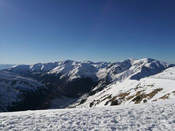 Snowcapped mountains against clear blue sky