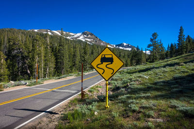 Information sign by road against sky