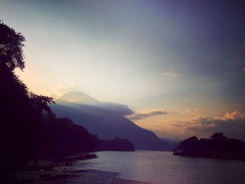 Scenic view of sea and silhouette mountains against sky