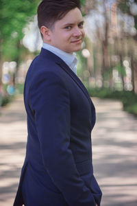 Young businessman standing on footpath