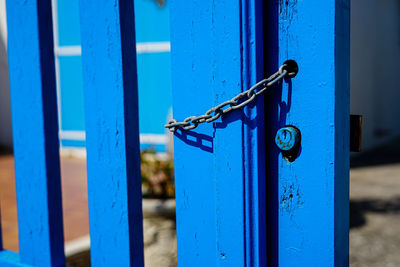 Close-up of gate against blue door