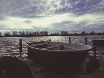 Boats in sea against cloudy sky