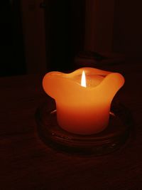 Close-up of illuminated tea light candle on table