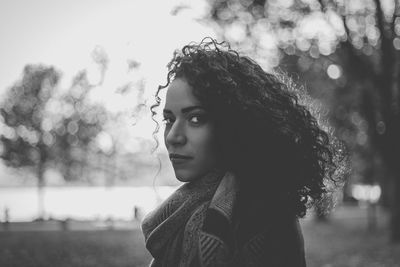 Portrait of young woman against tree