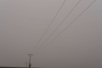 Low angle view of electricity pylon against sky