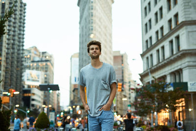 Portrait of smiling young man standing against cityscape