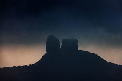 Low angle view of silhouette rock against sky at sunset