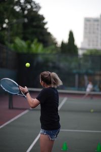 Rear view of woman playing with umbrella