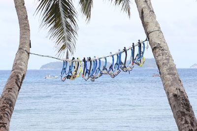 Clothes drying on clothesline by sea against sky