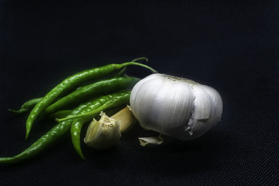 Close-up of green chili pepper against black background