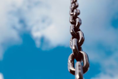 Low angle view of chain against sky