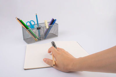 Cropped hand of woman working on table