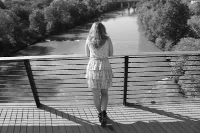 Rear view of woman standing by railing