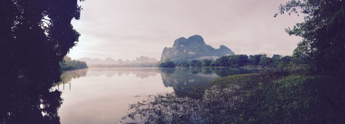 Scenic view of lake by trees against sky