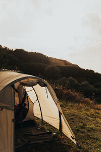 Tent on field by mountain against sky