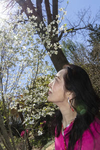 Portrait of woman looking away against trees