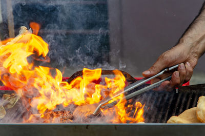 Midsection of man preparing food on barbecue grill