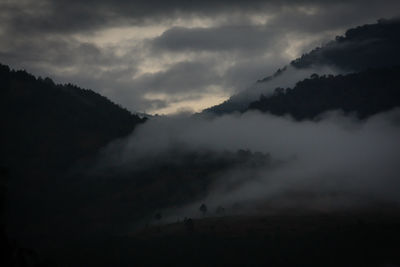 Scenic view of storm clouds over silhouette landscape