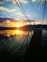 Pier on lake at sunset