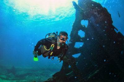 A man doing scuba diving near a shipwreck