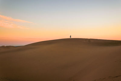 Scenic view of desert against sky during sunset