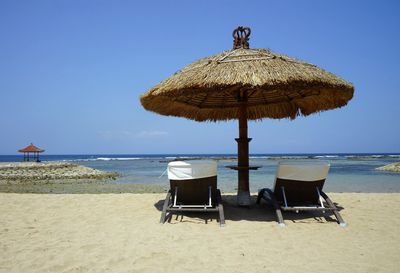 Lounge chairs and sunshade on sandy beach
