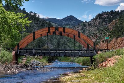 Arch bridge over river against sky