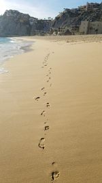 Footprints on beach against sky