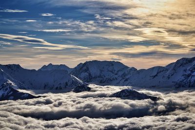 Idyllic shot of snowcapped mountains in clouds against sky