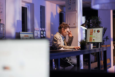 Businesswoman using laptop while standing in office