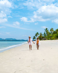 People at beach against sky