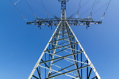 Low angle view of electricity pylon against clear sky