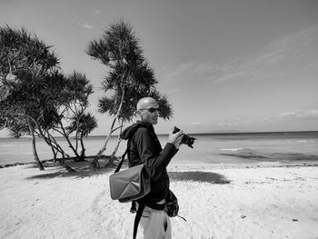 Full length of woman standing on beach against sky