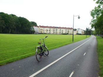 Bicycle on road in city against clear sky