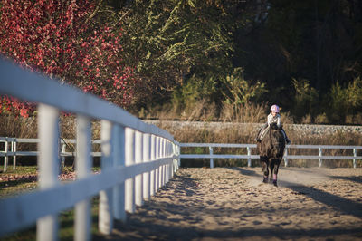 Girl riding horse in ranch