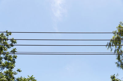 Low angle view of power lines against blue sky